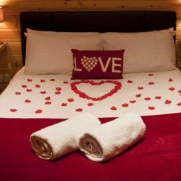 Schlafzimmer romantisch deko rote bettdecke rosenblatter.jpg