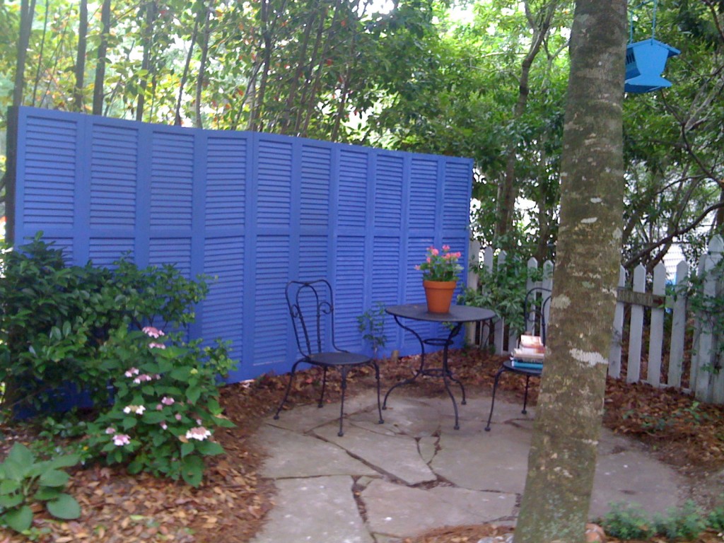Privacy fence made of assortd old shutters.jpg