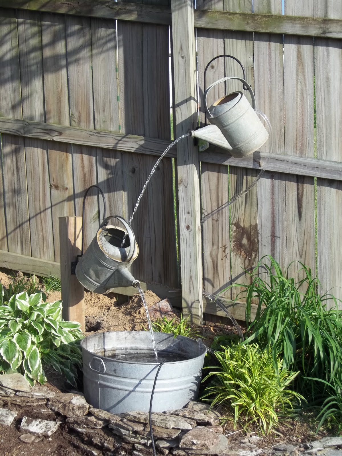 Create a small water feature using your old watering cans and pails.jpg