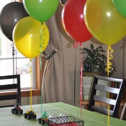 12 small toy cars with colorful balloons attached for a boys party.jpg