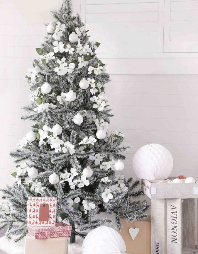 All white floral ornaments on snowy christmas tree.jpg