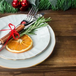 Christmas table layout red tape cinnamon stick rosmarin slice dry orange dark wooden background 81283426 768x512.jpg
