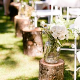 Wildflowers in mason jar on tree stump woodland wedding aisle.jpg