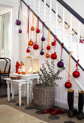 Staircase decorated with baubles and lit candles for Christmas